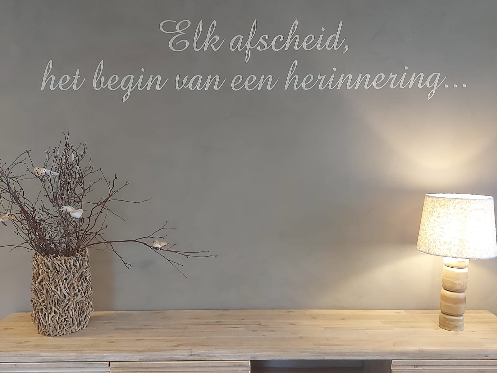De spreuk op de wand van de aula: elk afscheid, het begin van een herinnering